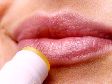 Lip balm being applied to lips.